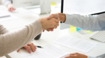 Handshake of man and woman after signing business contract, businessman and businesswoman shaking hands making employment agreement or hiring, buying insurance or becoming partners, close up view